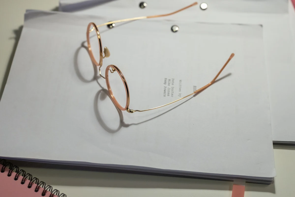 Eyeglasses resting on a stack of papers.